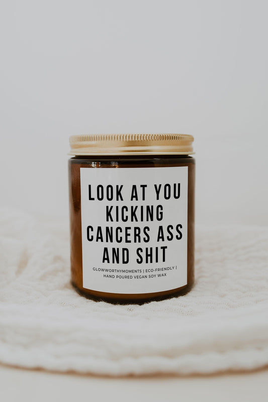 Smiling survivor with bold cancer candle during infusion