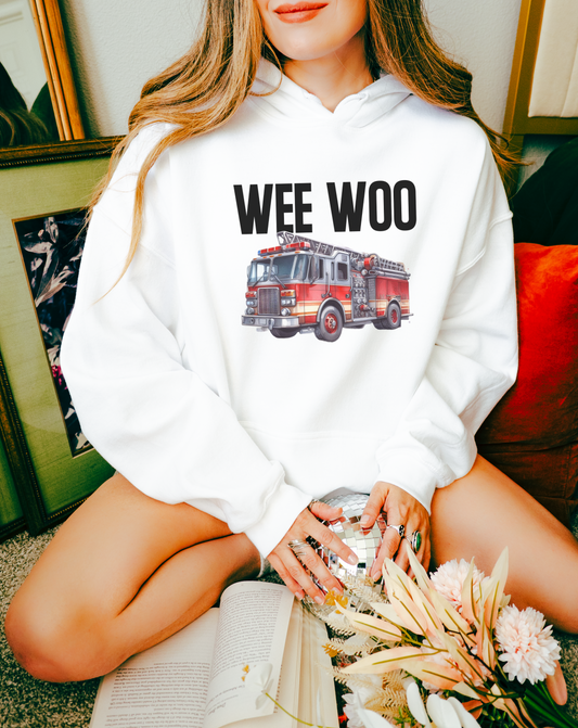 Fire academy graduate wearing 'Wee Woo' hoodie with classmates