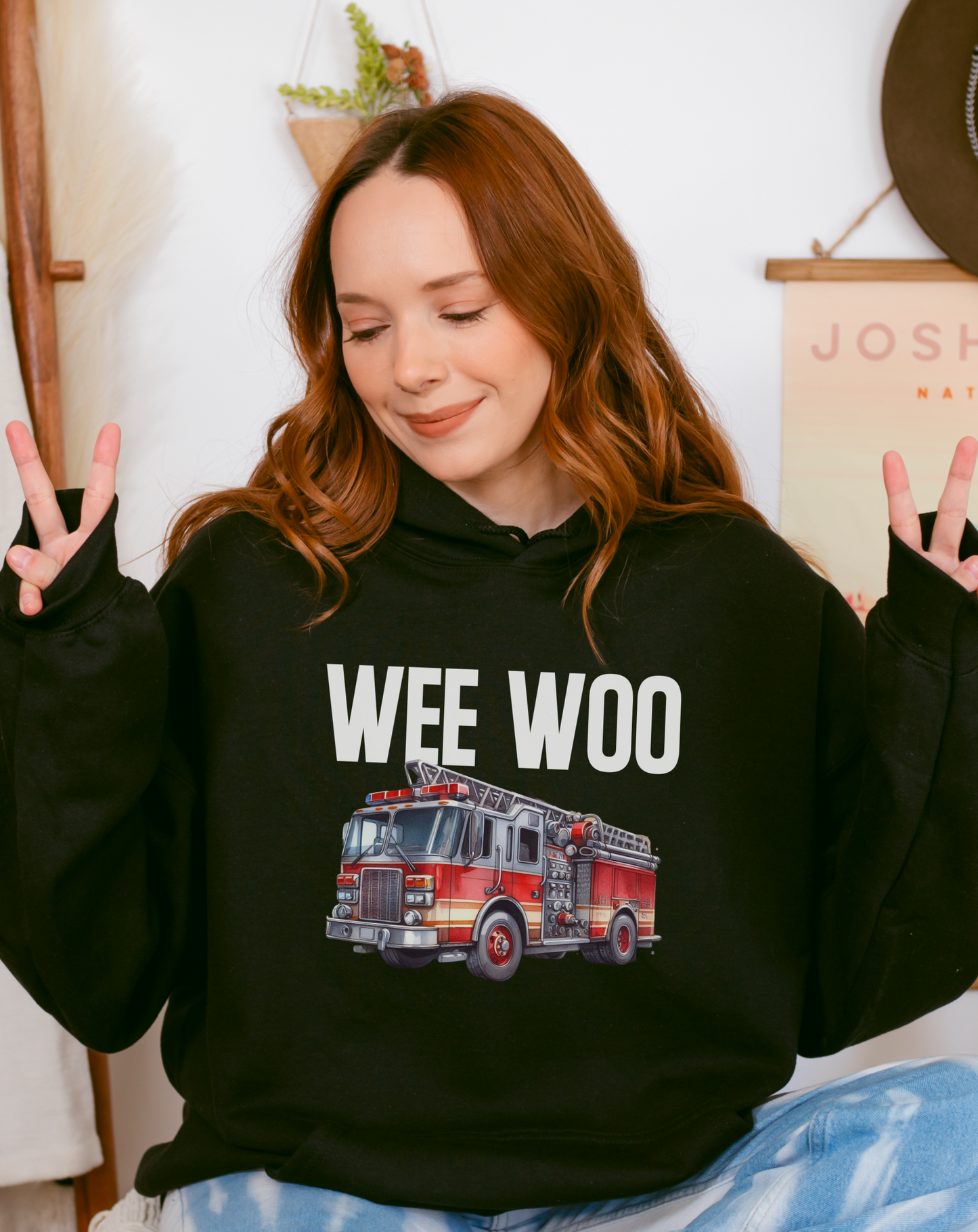 Group of firefighters in matching 'Wee Woo' hoodies at station