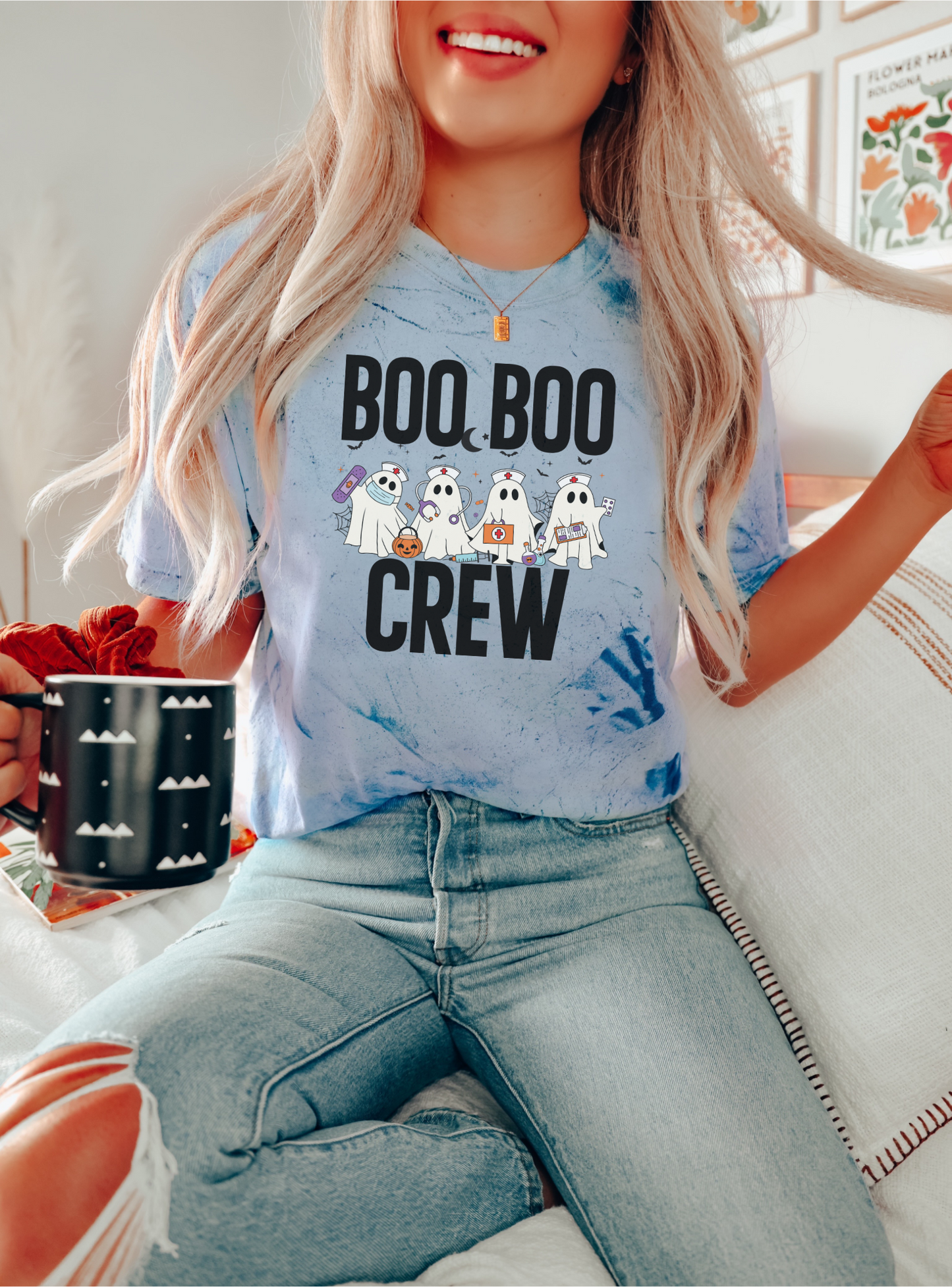Person wearing a blue t-shirt with 'BOO BOO CREW' text and ghost graphics, sitting indoors.