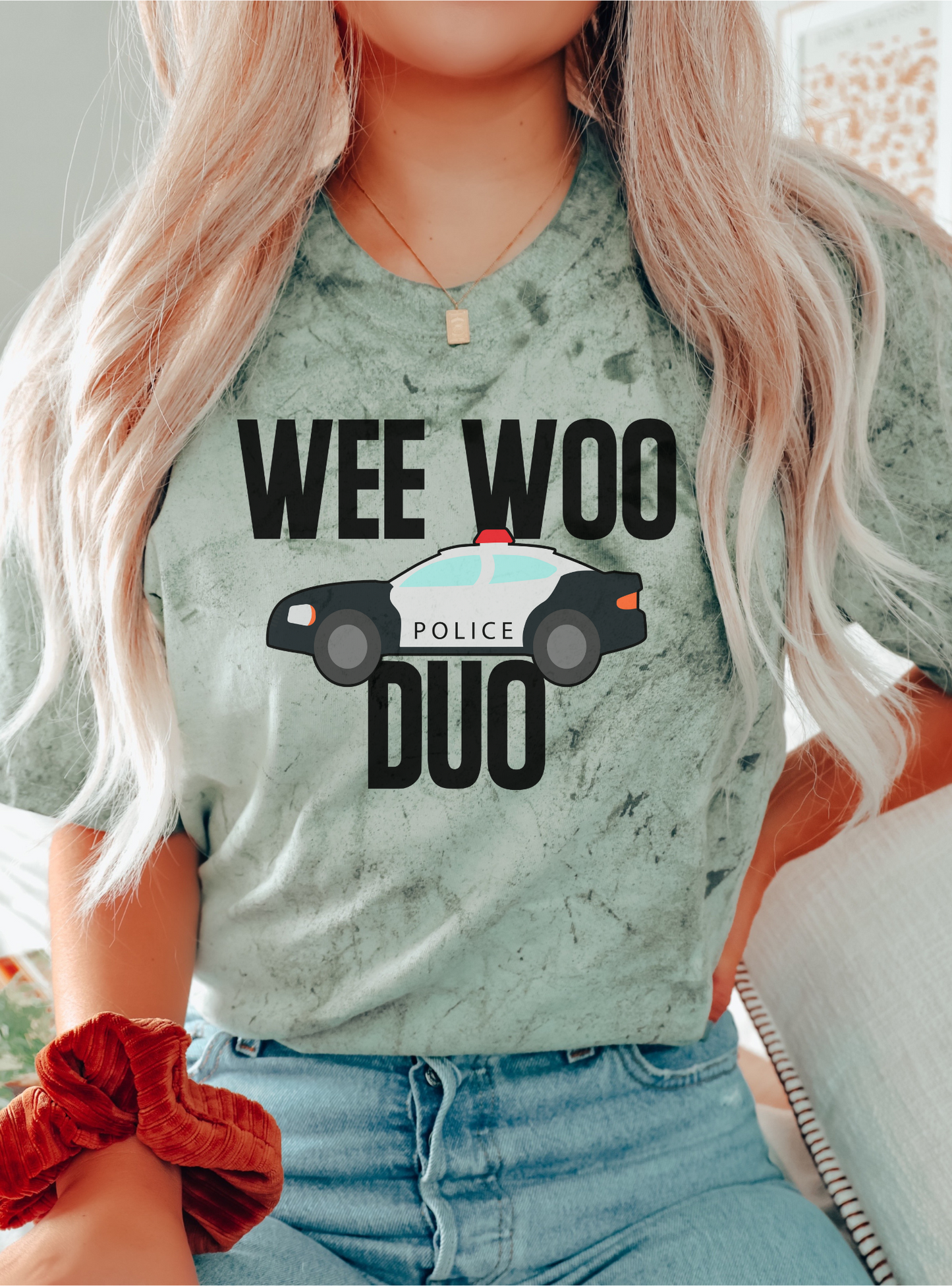 Person wearing a light green t-shirt with 'WEE WOO POLICE DUO' text and graphic.