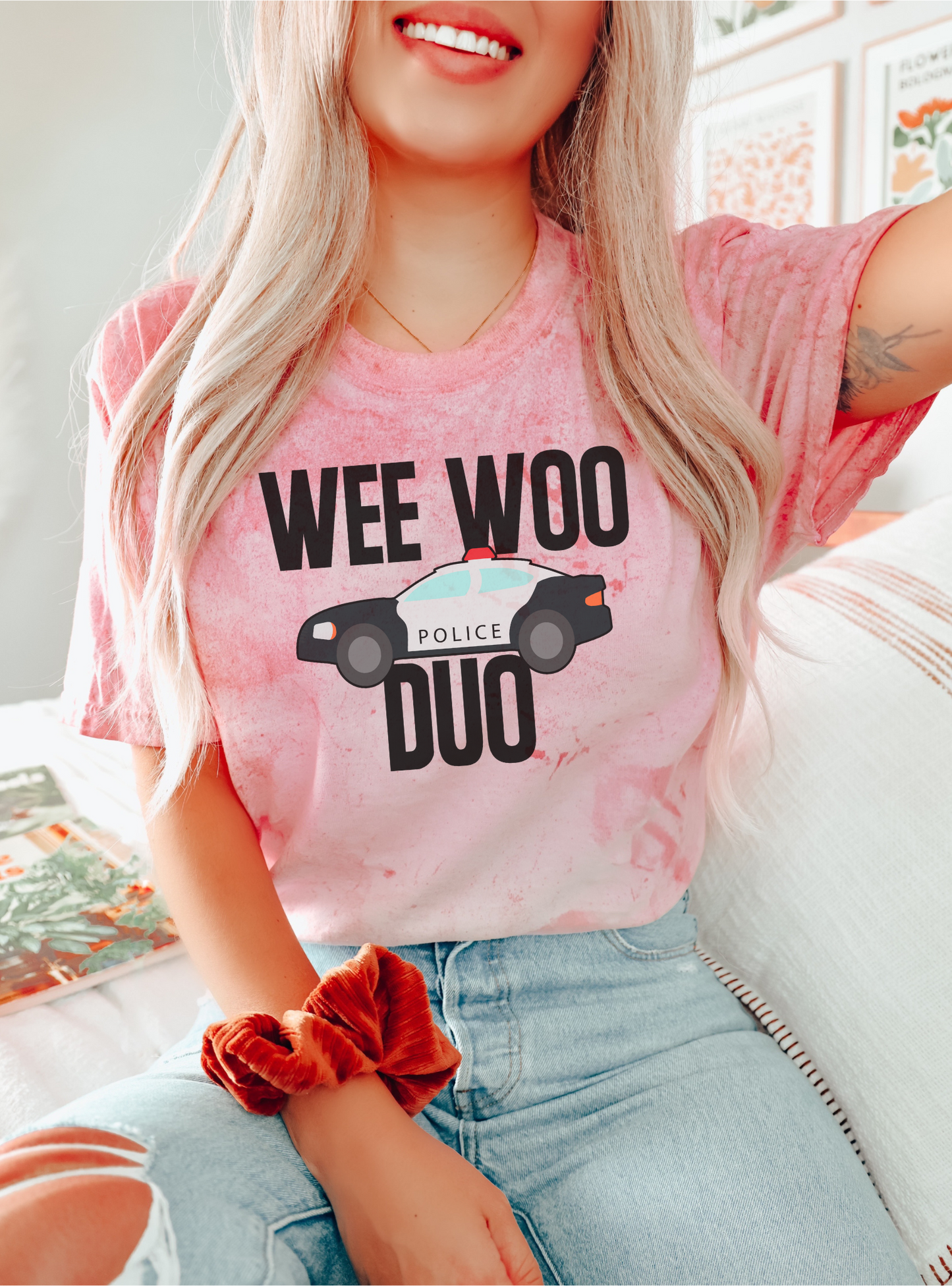Person wearing a pink t-shirt with 'WEE WOO DUO' text and police car graphic.