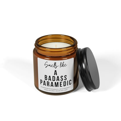 Candle in an amber jar with a black lid, featuring a label that reads 'Smells like a badass paramedic' on a white background.